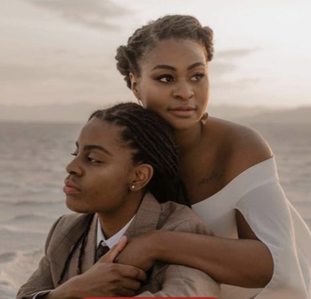 Two women in intimate embrace on beach/outdoor setting